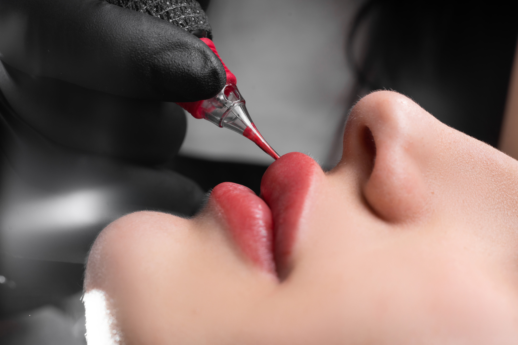 lip tattoo in a beauty salon, the process of applying coloring pigment to the lips, permanent lip makeup, female beauty